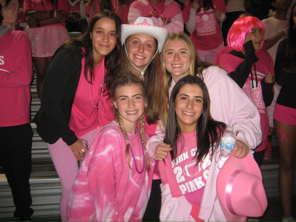 Students support breast cancer awareness by wearing pink to football game.