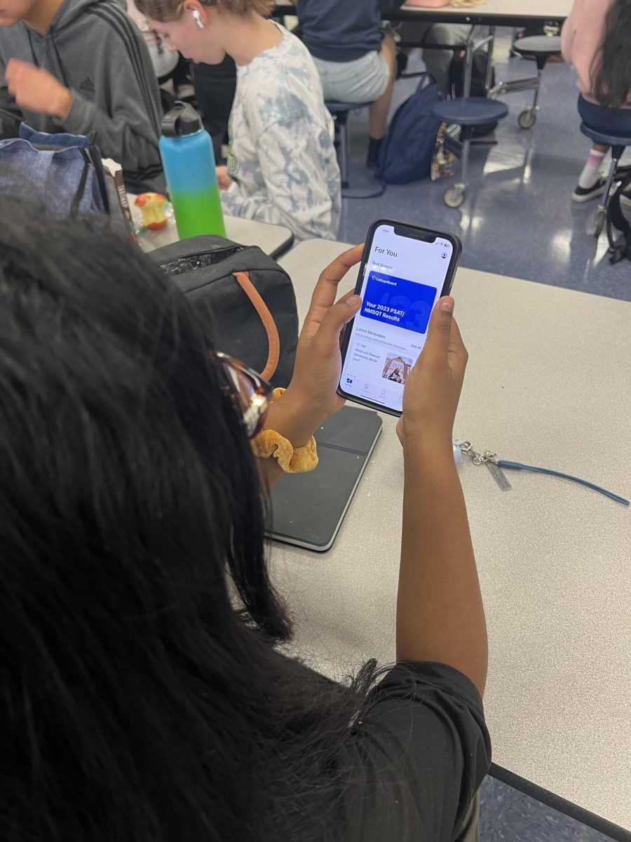 Junior Rithvika Yenugula looks at her PSAT/NMSQT scores on the BigFuture app on November 9th, 2023 in the John Champe High School Cafeteria.