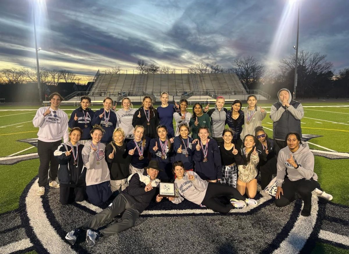 The Varsity Girls Track team is posing with their District Champion trophy. They took a photo together after the meet had concluded and all the other accolades had been presented. 