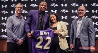 Running Back Derrick Henry holds his new Ravens uniform at a Press Conference.