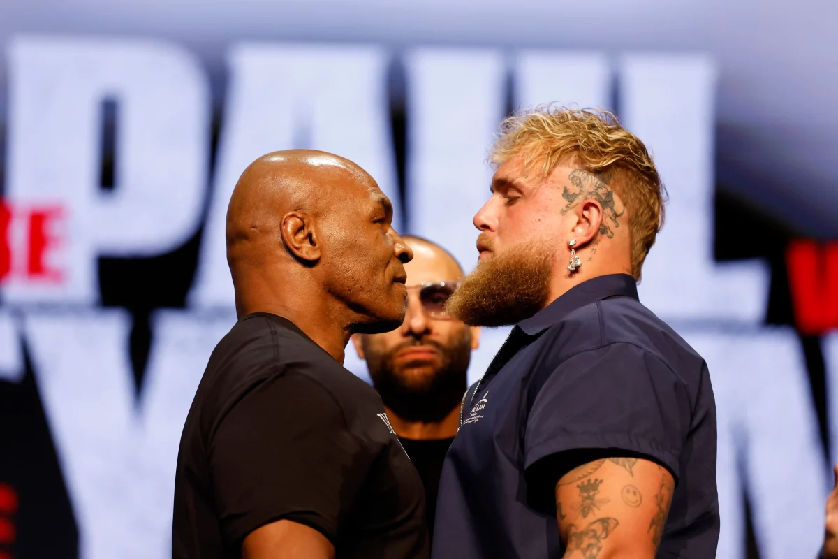 Mike Tyson (left) and Jake Paul (right) face off at their press conference one month before their boxing match