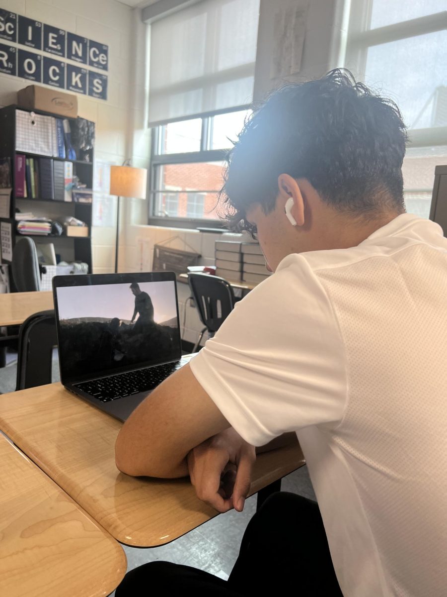 A high school student watching a drama series during instructional time. The student is clearly distracted and unable to focus with the device usage.