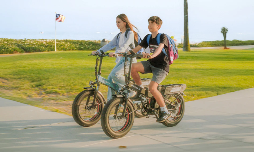 A stock photo depicting two students riding their Electric Bikes to school