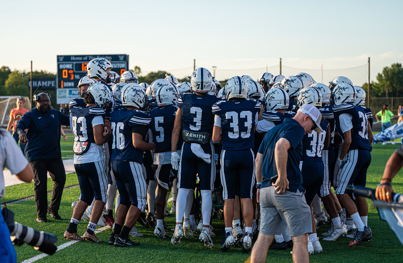 John Champe High School varsity football team huddling up before the start of the game. This was the first home game of the season, the win against Lightridge High School.