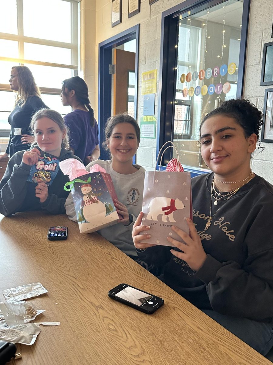 Sophomores Maddie Zalenski, Caroline Quinlivan, and Yasmin Rajeb with their Secret Santa gifts. 