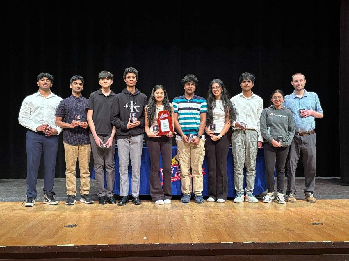 Champe's Scholastic team lined up with their medals and plaque for one last photo (Photo courtesy of Atharv Bapuram).