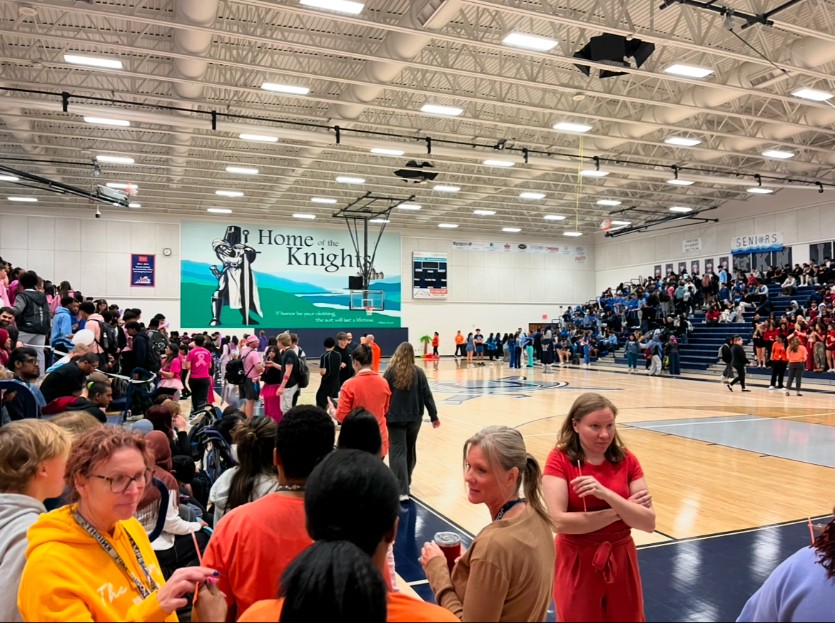 JCHS students sitting down in beachers before the start of their spring pep rally, April 11,2025 in the main gym. Students and staff sit in bleachers to watch the pep rally happen from the audience.